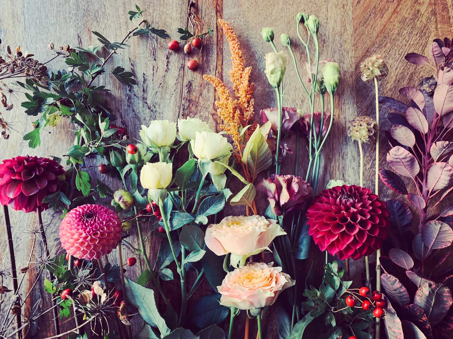 A selection of flowers laid on a table ready to be arranged